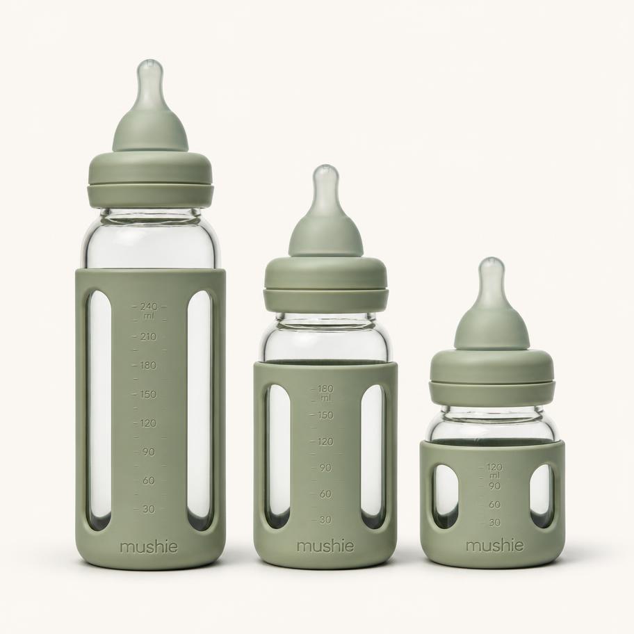 Glass Feeding Bottle Trio — Three borosilicate glass bottles with protective silicone sleeves.